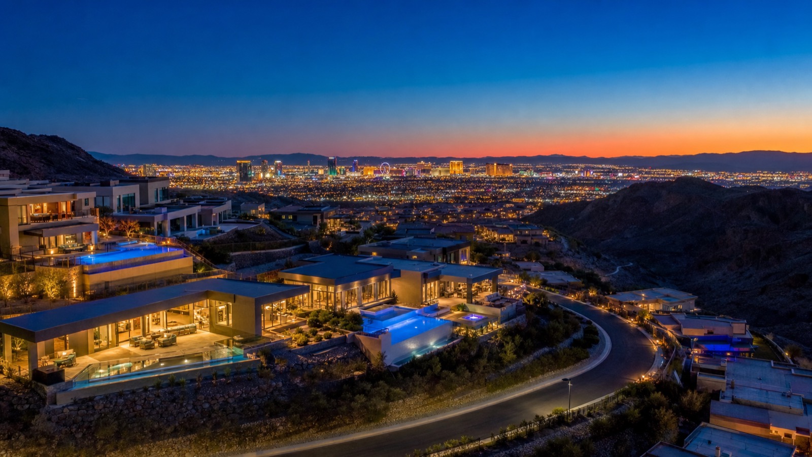 Henderson hillside community at twilight with Las Vegas Strip view in the distance and mountain silhouettes